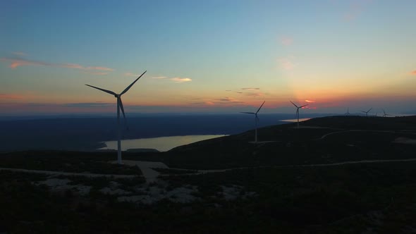 Aerial view of white elegant windmills at sunset alt