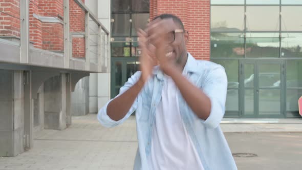 African Man Dancing in Celebration While Walking in Street