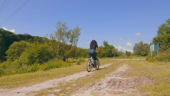 View From the Back of a Girl Riding a Bike on the Road