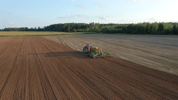 Farmer In Tractor Planting Seeds Of Grain Crops In Agricultural Field Aerial