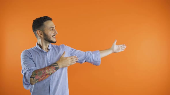 Young Man with Outstretched Arms To the Side Presenting Product Concept