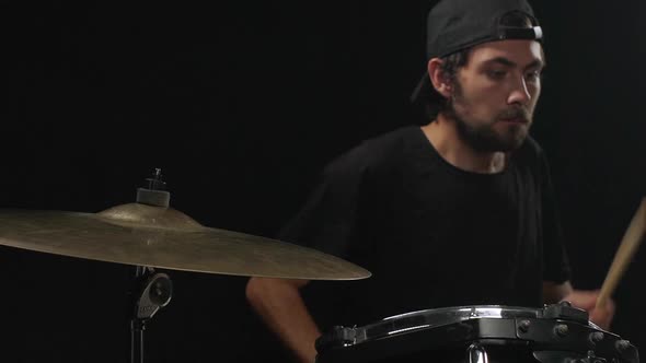 Guy Playing on Drums Over Black Background Slow Motion
