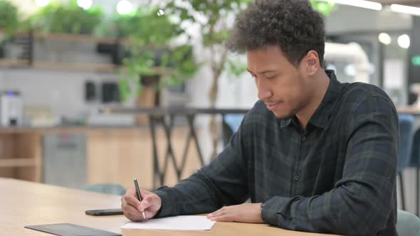 African American Man Failing at Writing on Paper