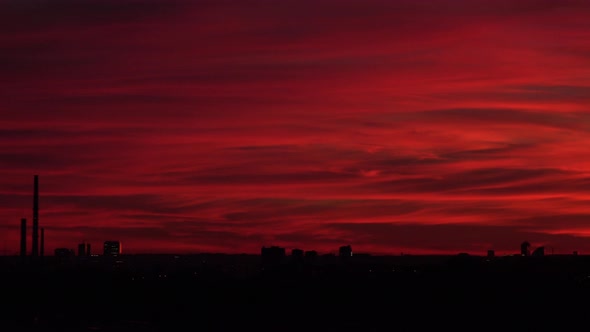 A Red Sunset Over a Dark Cityscape