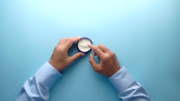  Man Applying Beauty Cream Onto Skin at Home Top View 