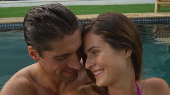 Happy Caucasian couple enjoying the pool during a sunny day