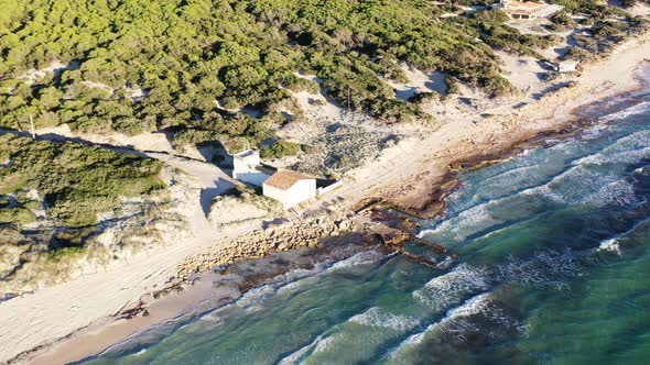 Trenc Beach in Mallorca Spain with small restaurant bar near a reclaimed building structure by the s