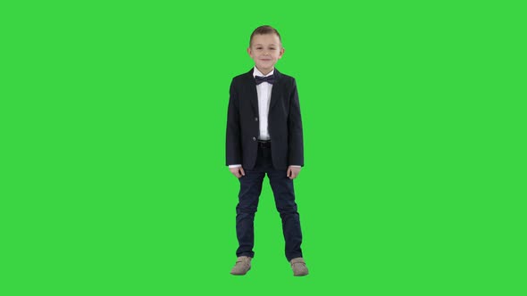 Smiling Little Boy in Formal ClothesStanding on a Green Screen, Chroma Key.