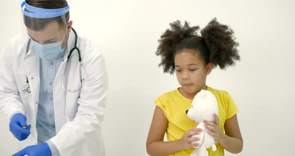 Male Pediatrician Giving a Vaccine Shot to a Black Kid