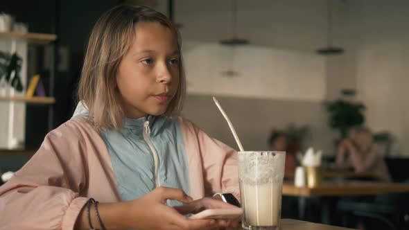 Beautiful Girl in Sitting in Cafe Counter and Drinking Milkshake While Taking Cute Photos on Her