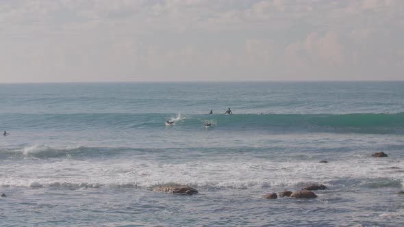 Two surfers manager to catch a wave in slow motion in Malibu on the West Coast USA