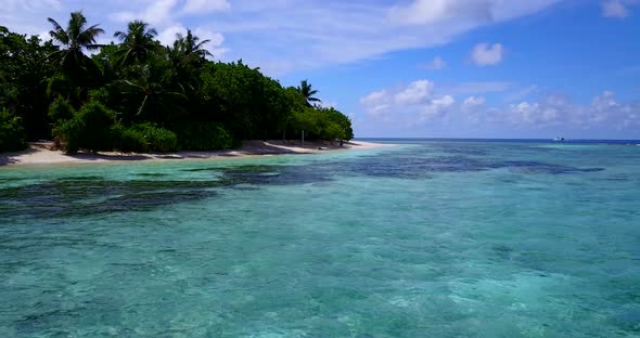 Beautiful fly over tourism shot of a white sandy paradise beach and blue ocean background in high re