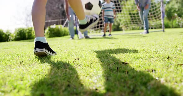 Family playing football in park