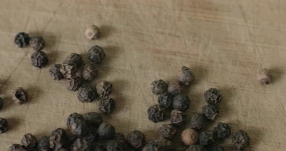 Detail of Peppercorns on a wooden cutting board