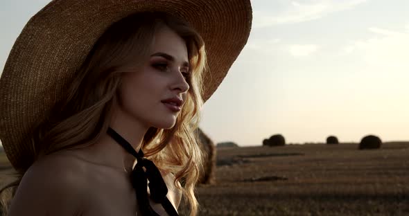 The Girl Walks Across The Field Among The Collected Sheaves Of Hay