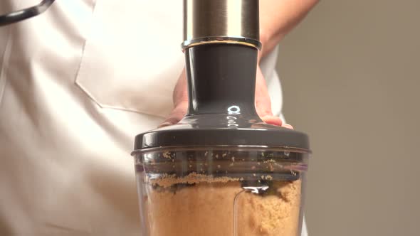 Woman handling mixer running with cookie dough to make cakes