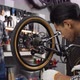 Young Asian man worker repairing bicycle wheel and gear in bicycle workshop - VideoHive Item for Sale