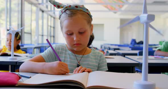 Caucasian schoolgirl notebook at desk in classroom 4k