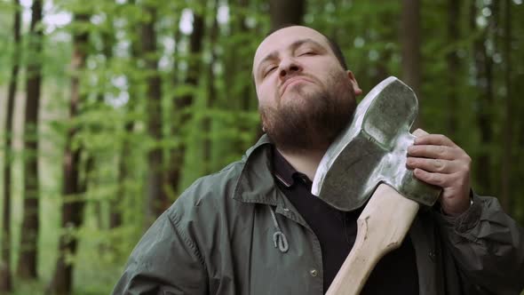 Slow Motion Of Casual Strong Man Has Shave with Ax in Wild Deciduous Forest.