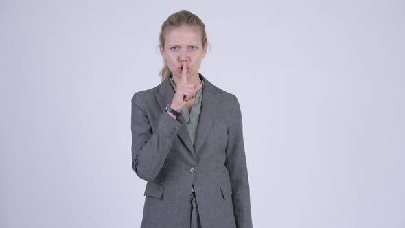 Young Stressed Blonde Businesswoman with Finger on Lips