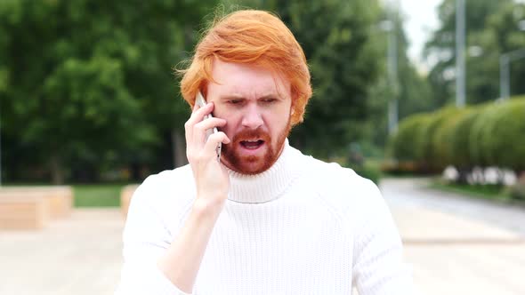 Angry Man with Red Hairs Talking on Phone at Work, Outdoor