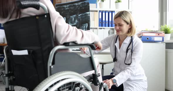 Doctor Explaining Xray Results to a Patient in Wheelchair in Hospital and Testing Sensitivity of
