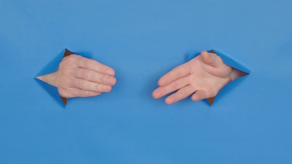 greeting hands through holes, on a blue background