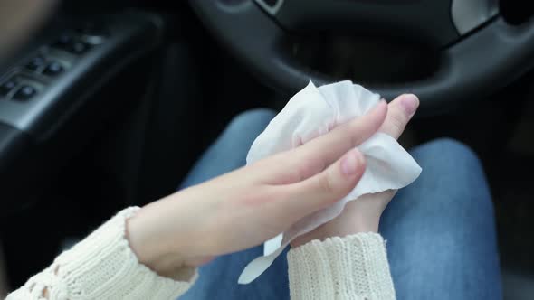 girl disinfects her skin with special antibacterial wipes sitting in a car