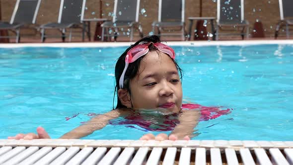 Asian Girl Swimming In The Pool On Summer