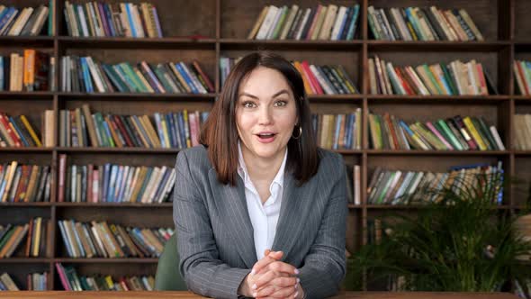 Successful Businesswoman Raises Hands in Happiness at Table