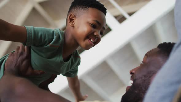 African american father and son playing together on the couch at home