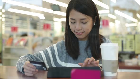 Woman using digital tablet computer in cafe