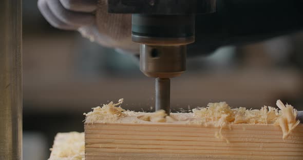 Craftsman Drills Holes in Wooden Plank with Drilling Machine in Slow Motion Carpentry at Workshop