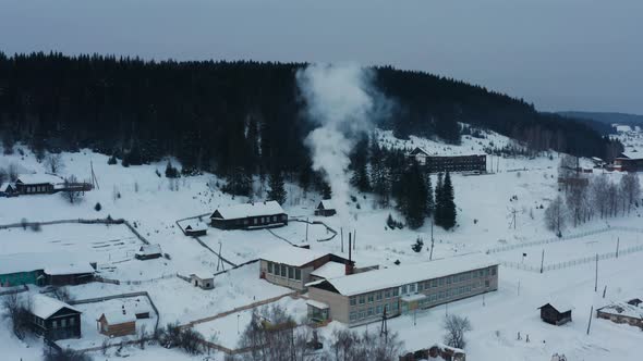 Aerial View of Smoke Coming From Stoves in Wooden Houses in the Village in Winter