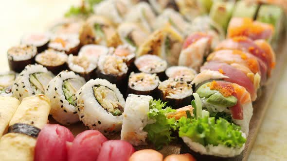 Top View Background with Set of Colorful Different Kinds of Sushi Rolls Placed on Wooden Board