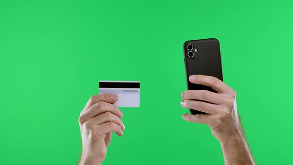 Male Hands are Holding Credit Card Smartphone on Chroma Key Green Screen Background