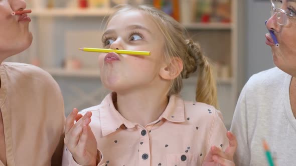 Little Girl Making Moustache With Pencil, Having Fun With Parents, Happiness