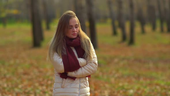 Young Attractive Girl Frozen in the Autumn Park, Warm Hands.