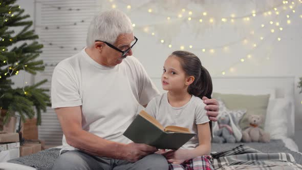 Grandparent Talking to Little Granddaughter before Bed at Christmas