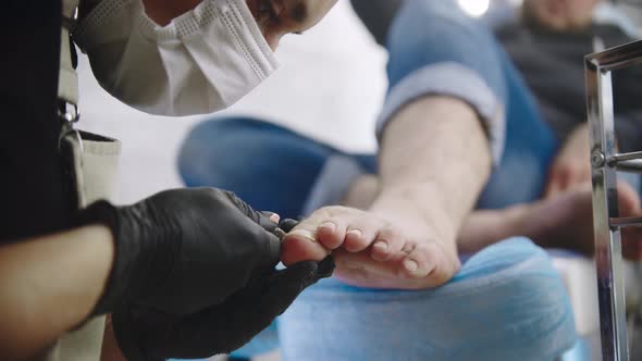 Pedicure Master Cutting Toenails Her Male Client Using Nail Clippers