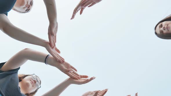 Friends Make a Circle with Their Palms Against the Blue Sky