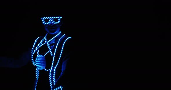 Portrait of a Young Woman Dancing in the Dark in a Costume with LED Lights