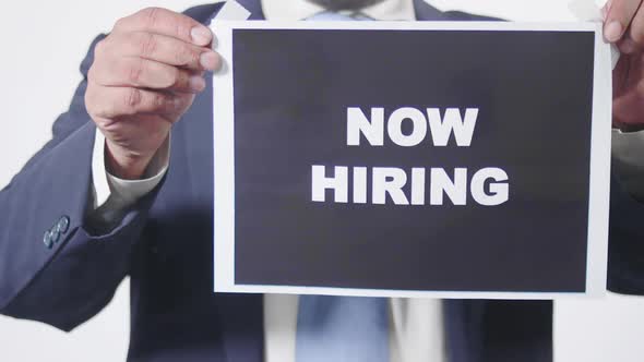 Businessman Posts Sign On Window Now Hiring 