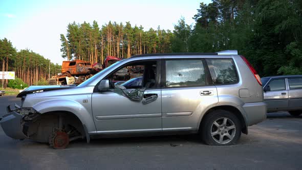 Side View Broken Car with Bullet Holes Outdoors in Automobile Dump Outdoors