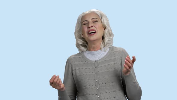 Funny Senior Woman Is Laughing on Blue Background