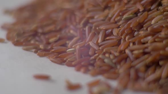 Heap of Red Rice Close Up Pouring Down. Red Rice Closeup. Slow Motion. Food Video