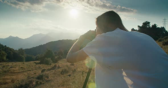 Woman Using DSLR Camera on Tripod Photographing Mountain Landscape