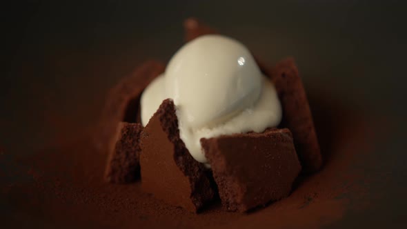 Serving chocolate brownie dessert decorated with ice cream in a professional restaurant kitchen