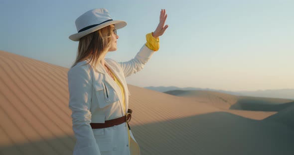 Attractive Girl Standing in Desert at Sunset