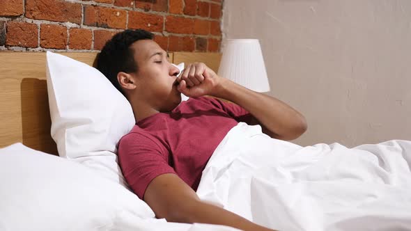 Coughing Sick African Man Lying in Bed at Night